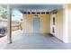 A yellow shed with a blue door sits on a concrete slab covered with a metal awning at 706 Lynn Ave, New Smyrna Beach, FL 32168