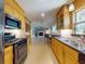 Charming kitchen featuring warm wood cabinetry, stainless steel appliances, and plenty of countertop space at 706 Lynn Ave, New Smyrna Beach, FL 32168