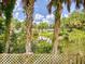 Lake view from backyard featuring tropical palm trees, verdant foliage, and a lattice fence in the foreground at 706 Lynn Ave, New Smyrna Beach, FL 32168