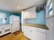 The laundry room features white cabinets with counter space, plus a refrigerator and a hanging drying rack at 706 Lynn Ave, New Smyrna Beach, FL 32168