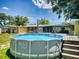 Backyard view with above-ground pool and wooden deck, ideal for outdoor entertaining in a private setting at 706 Lynn Ave, New Smyrna Beach, FL 32168