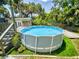 Above ground pool surrounded by green turf and a wooden deck with stairs and metal railings at 706 Lynn Ave, New Smyrna Beach, FL 32168
