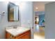 Powder room showcasing a vanity with a granite top and framed mirror, offering a clean and classic look at 706 Lynn Ave, New Smyrna Beach, FL 32168