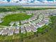 Aerial view of homes in a Gathering-friendly community with sidewalks, manicured lawns and community pool by a small lake at 7367 Catania Loop, Clermont, FL 34714