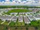 Aerial view of the community with landscaped lawns, sidewalks and community pool on a green field surrounded by homes at 7367 Catania Loop, Clermont, FL 34714