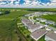An aerial view of a lovely community with green spaces and well-maintained homes under a partly cloudy, bright blue sky at 7367 Catania Loop, Clermont, FL 34714
