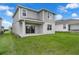 Two-story home with a sliding glass door leading to the backyard and lawn at 7367 Catania Loop, Clermont, FL 34714