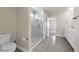 Modern bathroom with a glass shower, toilet, single vanity and tiled floors at 7367 Catania Loop, Clermont, FL 34714