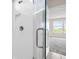 Bright bathroom with glass shower, tiled walls and floor, and a view to the bedroom and beyond at 7367 Catania Loop, Clermont, FL 34714