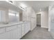 Bathroom showcasing a double sink vanity, quartz countertop, tiled floor, and glass shower with bright lighting at 7367 Catania Loop, Clermont, FL 34714
