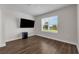 Bedroom with a large window overlooking the back yard and wood-look floors at 7367 Catania Loop, Clermont, FL 34714