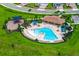 Aerial view of a beautiful community pool featuring a covered seating area, lounging chairs and a playground at 7367 Catania Loop, Clermont, FL 34714