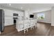 Modern kitchen with white cabinets, stainless appliances, and island with white stools at 7367 Catania Loop, Clermont, FL 34714
