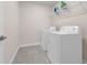 Functional laundry room features modern appliances and ample shelving for organization at 7367 Catania Loop, Clermont, FL 34714