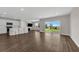 Open-concept living room boasts hardwood floors, lots of natural light, and kitchen with stainless appliances at 7367 Catania Loop, Clermont, FL 34714