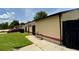 Tan home featuring a tidy side yard with concrete walkway, complemented by dark fencing and landscaped elements at 761 Golden Sunshine Cir, Orlando, FL 32807