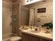 Bright bathroom featuring a tiled tub-shower, single sink vanity, and decorative mirror at 8647 Black Mesa Dr, Orlando, FL 32829