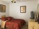A cozy bedroom with a patterned bedspread, decorative paintings, and a large television at 8647 Black Mesa Dr, Orlando, FL 32829