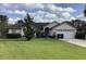 Charming single-story home with a well-manicured lawn, blossoming bushes, and attached two-car garage at 8647 Black Mesa Dr, Orlando, FL 32829