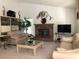 Bright living room features a brick fireplace, carpet floors, and neutral furniture at 8647 Black Mesa Dr, Orlando, FL 32829