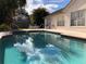 Beautiful pool reflecting the sky, surrounded by patio furniture and mature trees at 8647 Black Mesa Dr, Orlando, FL 32829
