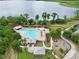 Aerial view of community pool, playground, and lake, surrounded by lush greenery in a serene setting at 8752 Lookout Pointe Dr, Windermere, FL 34786
