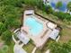 Aerial view of community pool, splash pad, and lounge chairs surrounded by lush greenery, creating a relaxing oasis at 8752 Lookout Pointe Dr, Windermere, FL 34786