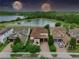 Aerial view of a two-story home near a tranquil lake and lush greenery showcases a serene and picturesque setting at 8752 Lookout Pointe Dr, Windermere, FL 34786