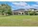 Backyard and exterior of home featuring a screened-in patio and lush green lawn at 8752 Lookout Pointe Dr, Windermere, FL 34786