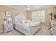 Inviting bedroom with a floral comforter, a white wooden bed frame, and a bedside table at 8752 Lookout Pointe Dr, Windermere, FL 34786