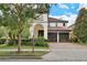 Charming two-story home with lush landscaping and a red tile roof has great curb appeal in a lovely neighborhood at 8752 Lookout Pointe Dr, Windermere, FL 34786