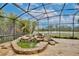 Screened lanai with rock waterfall and view of pond and wooded property in the distance at 8752 Lookout Pointe Dr, Windermere, FL 34786