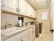 Bright laundry room with white cabinets, countertops, and stainless steel appliances at 8752 Lookout Pointe Dr, Windermere, FL 34786