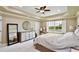 Comfortable main bedroom featuring tray ceilings, a large window, and neutral decor at 8752 Lookout Pointe Dr, Windermere, FL 34786
