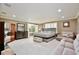 Expansive main bedroom with seating area, large windows, dark dresser, and neutral-toned furniture at 8752 Lookout Pointe Dr, Windermere, FL 34786