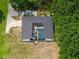 Aerial view of a gray roofed home with a screened-in pool area and green surrounding trees at 9353 Gotha Rd, Windermere, FL 34786