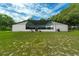 A large screened lanai is showcased in this backyard, surrounded by green grass at 9353 Gotha Rd, Windermere, FL 34786