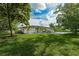 Backyard view with expansive green grass, fence line, mature trees, and blue skies at 9353 Gotha Rd, Windermere, FL 34786