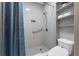 This updated bathroom features bright white tile, open shelving, and modern toilet at 9353 Gotha Rd, Windermere, FL 34786