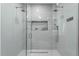 Luxurious walk-in shower with dual shower heads, sleek tile, and built-in niche for toiletries at 9353 Gotha Rd, Windermere, FL 34786