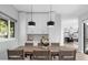 Dining room featuring a wooden table and modern light fixtures adjacent to white storage cabinets at 9353 Gotha Rd, Windermere, FL 34786