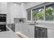 Bright kitchen with white cabinets, stainless steel appliances, and a window overlooking the yard at 9353 Gotha Rd, Windermere, FL 34786