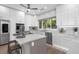 Bright kitchen features white cabinetry, stainless appliances, a center island with seating, and an exterior view at 9353 Gotha Rd, Windermere, FL 34786