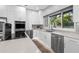 Modern kitchen featuring white cabinets, stainless steel appliances, and an ample window showcasing the lush outdoors at 9353 Gotha Rd, Windermere, FL 34786