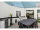 Covered outdoor kitchen boasts built-in grill, beverage center, counter space, and dining area at 9353 Gotha Rd, Windermere, FL 34786