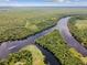 An aerial view showcases the river's scenic bends flowing through lush, green landscapes at 100 Verde Way, Debary, FL 32713