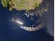 An aerial view captures two boats cruising along the glistening water at 100 Verde Way, Debary, FL 32713