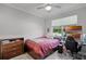 Simple bedroom with a comfortable bed, wooden dresser, and a view of the outdoors at 100 Verde Way, Debary, FL 32713
