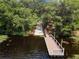 A beautiful wooden dock on the water surrounded by mature trees and lush vegetation at 100 Verde Way, Debary, FL 32713