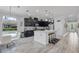 Bright kitchen with dark cabinets, stainless appliances, a central island, and an adjacent dining area at 100 Verde Way, Debary, FL 32713